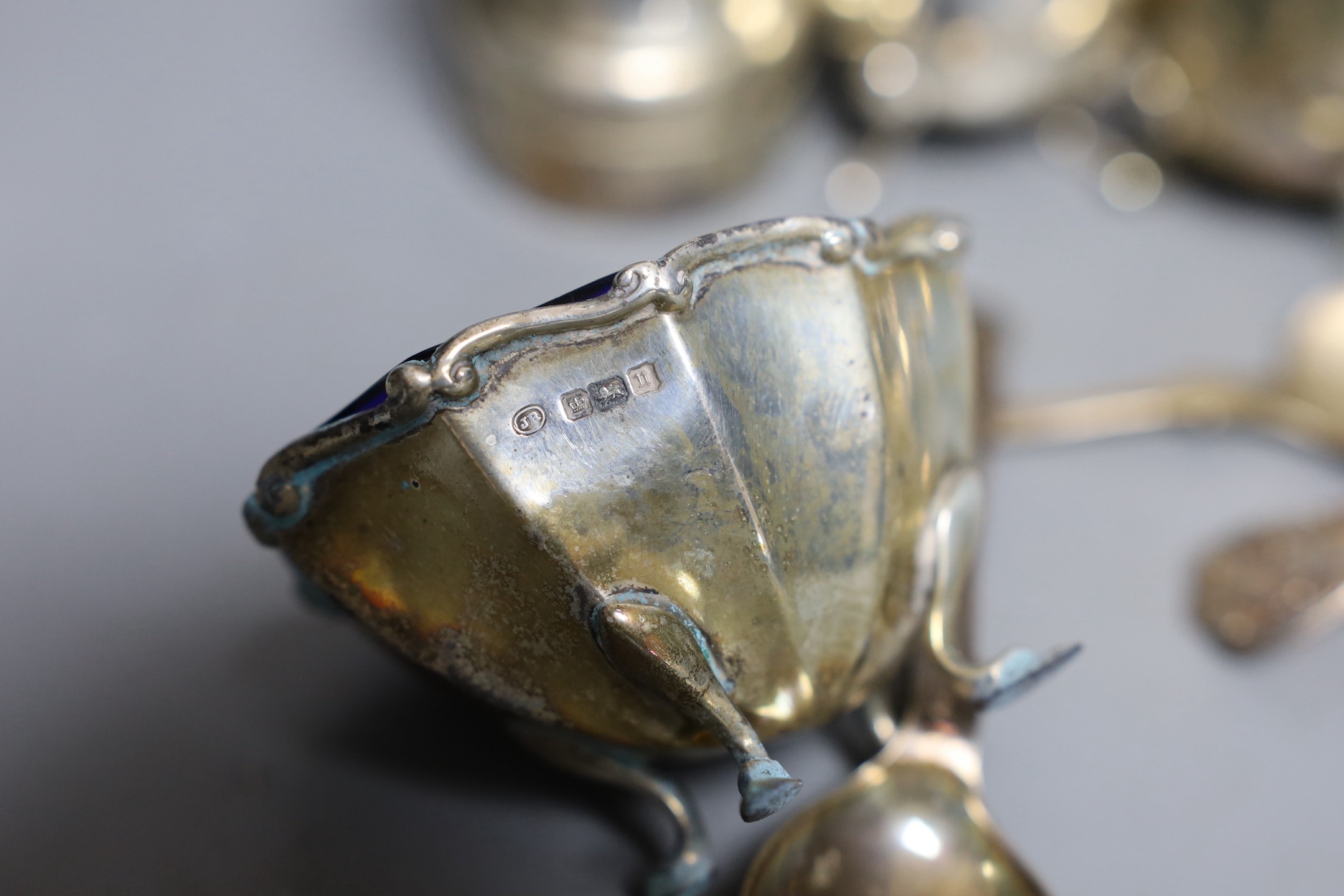 A modern pair of silver capstan shaped pepper mills, a pair of silver salts and pepper pots, a pair of matching salts and three various spoons.